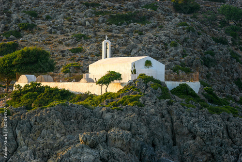 View of SANTORINI GREECE FIRA White Church Cross Archon a top of a mountain with grassland photo