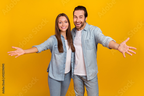 Photo of good mood excited sister brother dressed denim shirts ready hug you isolated yellow color background