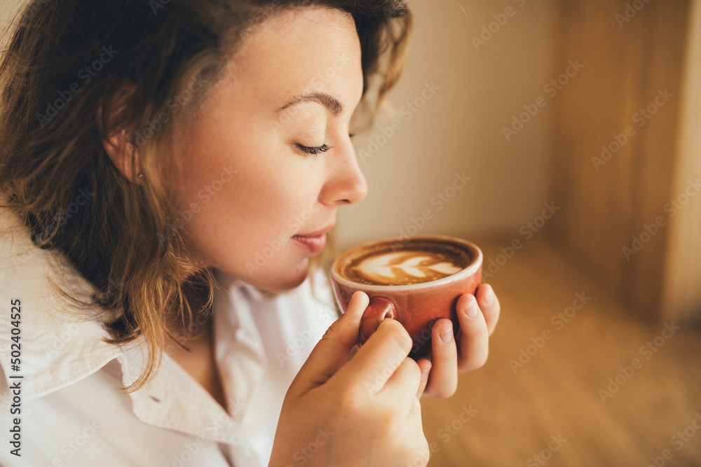 Millennial woman enjoying drinking fresh aromatic coffee cappuccino Millennial woman enjoying drinking fresh aromatic coffee cappuccino