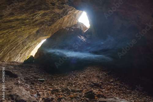 fog inside of cave Grosse Burghoehle with light from the exit, Balve, Sauerland, Germany