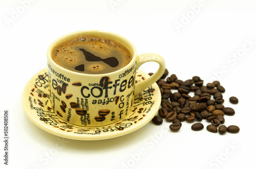 TurkishGreek coffee in a coffee cup with coffee written on it, with coffee beans next to it on a white background photo