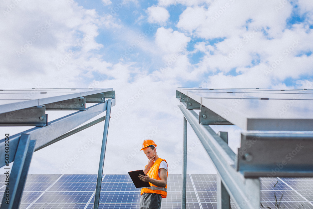 Repair man walking in the field with solar panels Repair man walking in the field with solar panels
