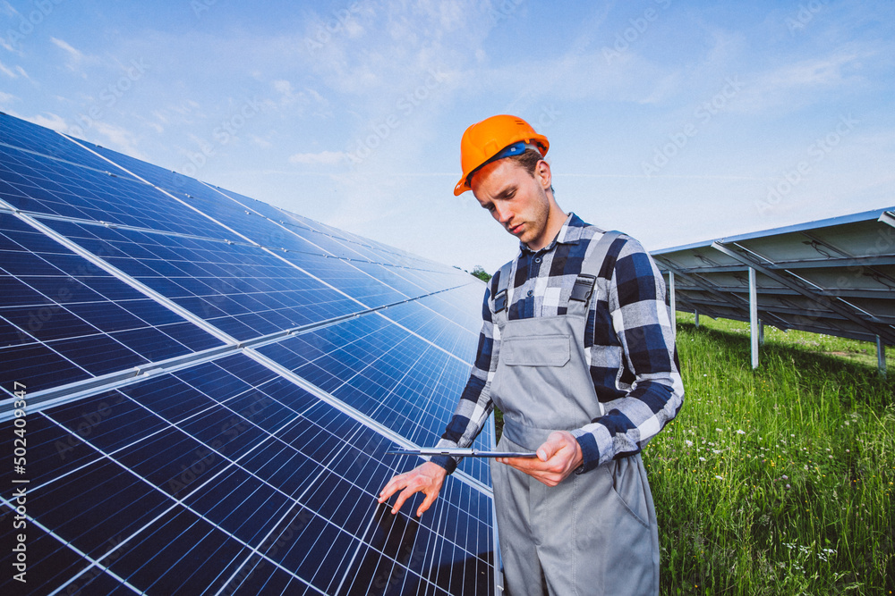 Repair man walking in the field with  solar panels