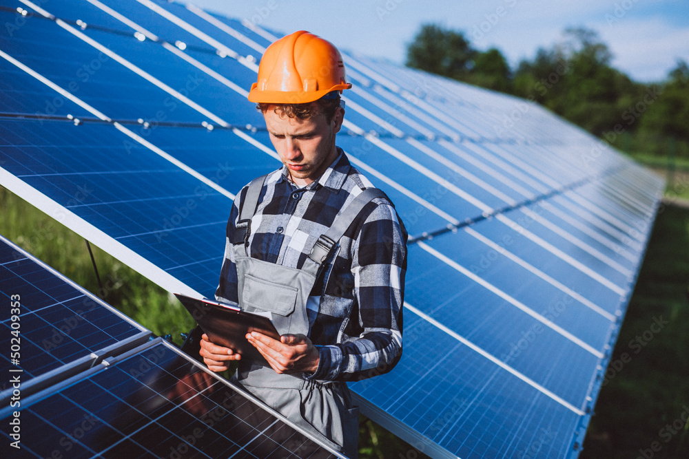 Repair man walking in the field with  solar panels