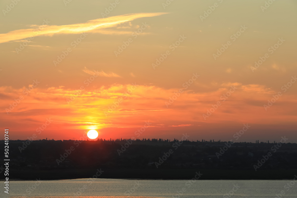 Picturesque view of beautiful cloudy sky over river at sunrise