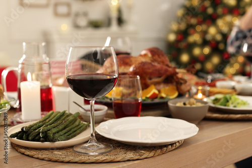 Festive dinner with delicious food and wine on table indoors, space for text. Christmas celebration