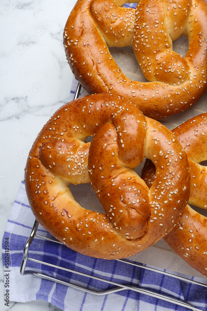 Cooling rack with delicious freshly baked pretzels on white marble table, top view Cooling rack with delicious freshly baked pretzels on white marble table, top view