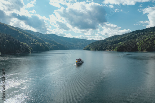 Passenger boat cruising on a calm sea with mountainous landscape and bight sky