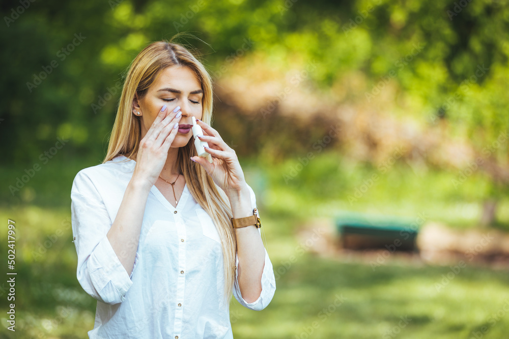 Nasal Spray, Female hand spraying nasal spray with blurred background. Woman Using Nose Spray. Young Woman is Having Sinusitis Problems Outside in Nature. Nasal Spray, Female hand spraying nasal spray with blurred background. Woman Using Nose Spray. Young Woman is Having Sinusitis Problems Outside in Nature.
