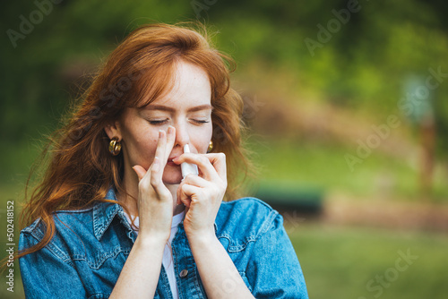 Taking nose drops because of pollen allergy. Woman is having flu and she is using nasal spray to help herself. Woman using nasal spray. Nasal spray to help a cold. Sick woman dripping nose.