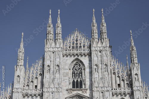 Famous Cathedral of Duovo on blue sky background in Milan Italy photo