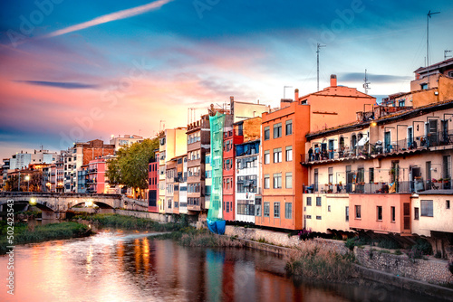 Beautiful view of the medieval city of Girona Spain with canal and historic colorful buildings seen at sunset. © littleny