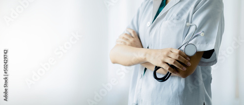 A doctor standing with his arms crossed holding a stethoscope, a doctor from the hospital. Medical staff people. Team of doctor and nurse in hospital. Concept Of Medical and Healthcare Business.