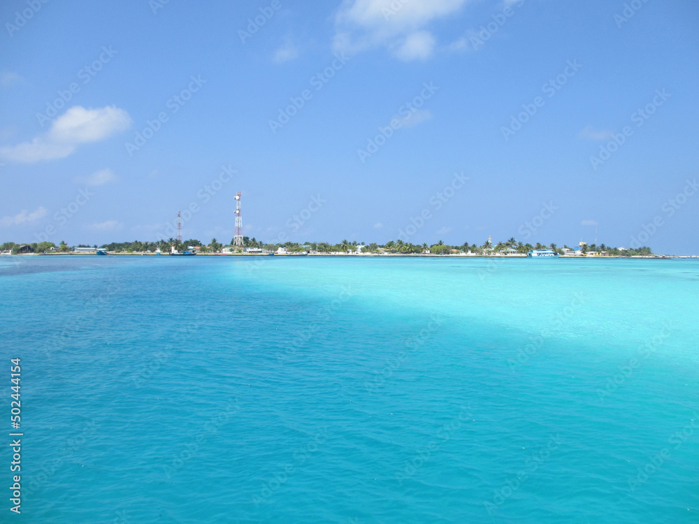 Maldives. Indian Ocean. Brown algae can be seen through clear turquoise water.