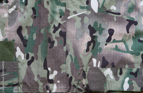 Camouflage army military fabric, with elements of pockets. Camouflage pattern background. Forest texture colors.