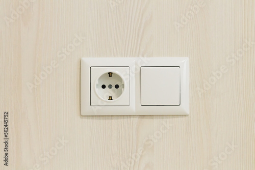 European electrical socket outlet and switch on wooden wall