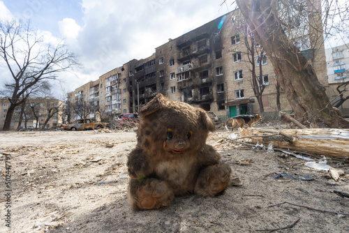 Concept war in Ukraine, a burnt bear toy against the background of a damaged house