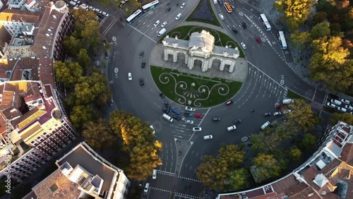 Shooting from a drone at the Puerta de Alcala monument surrounded by houses.
