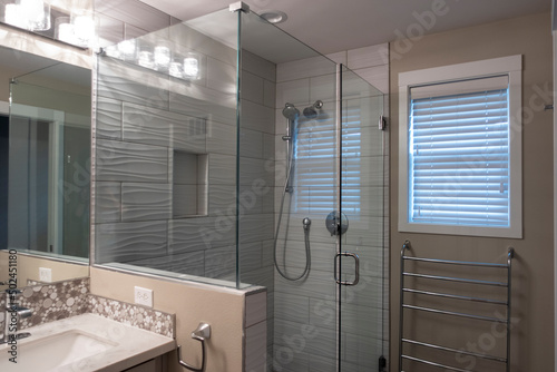 Angled view of a glass enclosed shower with a detachable showerhead