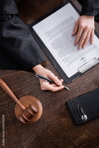 Εκτύπωση καμβά top view of cropped prosecutor with pen near lawsuit and gavel.