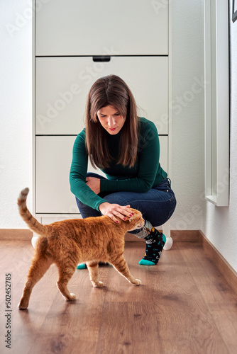 Woman stroking her cat inside her house