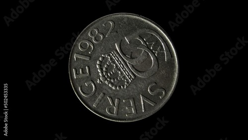 Obverse of Sweden coin 5 kronor 1982 with inscription meaning SWEDEN and monogram of king Carl XVI Gustaf. Isolated in black background. photo