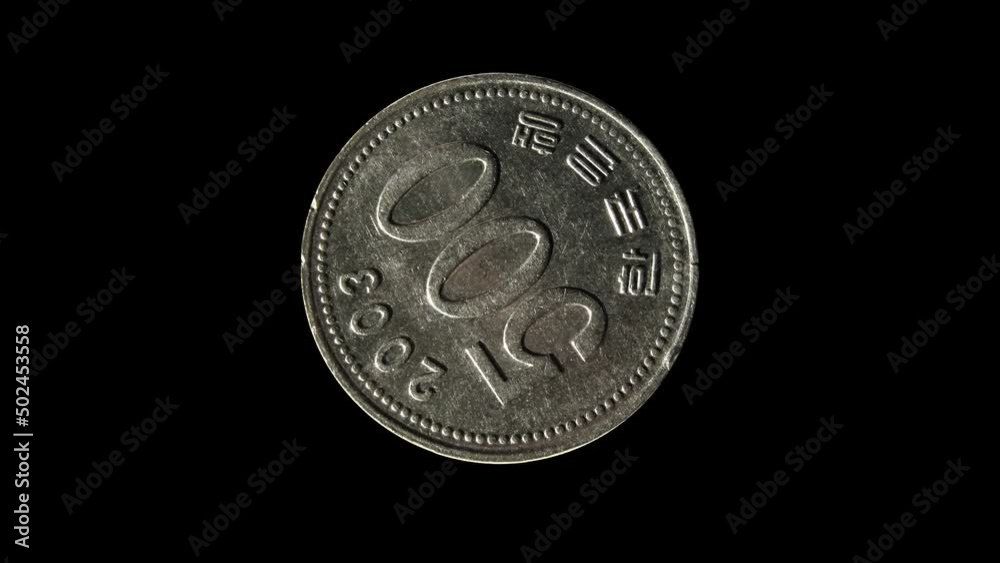 Rotating reverse of South Korea coin 500 won 2003 wiht inscription meaning BANK OF KOREA. Isolated in black background.