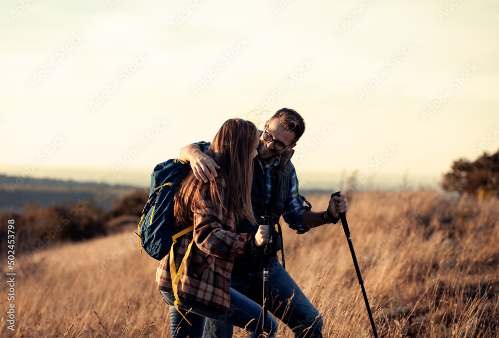 Couple with backpacks hiking together in nature.