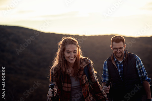 Couple with backpacks hiking together in nature.