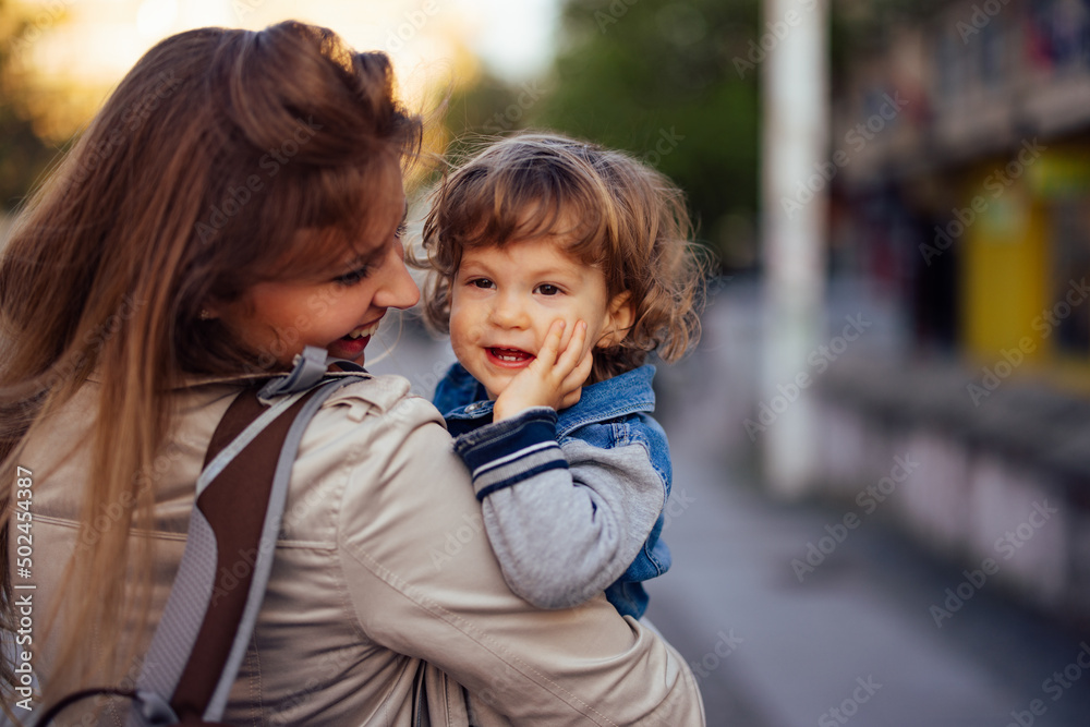 Young mother enjoying with her son, holding him, smiling together. Young mother enjoying with her son, holding him, smiling together.