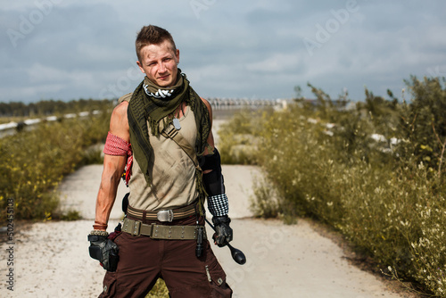 фотографія portrait of a vandal man with a baton, in dirty clothes against the backdrop of