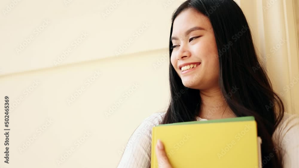 Student asian girl in eyeglasses near the university building looking ahead. Happy and smiling young woman. Student asian girl in eyeglasses near the university building looking ahead. Happy and smiling young woman.