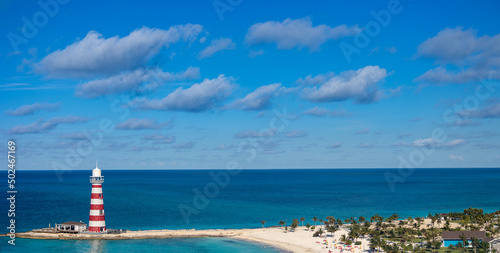 A lighthouse on an beach extension on a tropical island during clear, sunny day © Ivelin