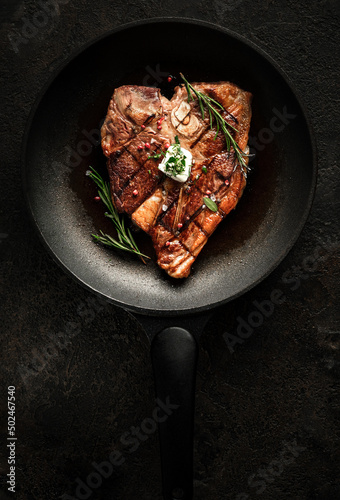 Fotografia Grilled t-bone steak with seasonings, rosemary and butter in a grill pan