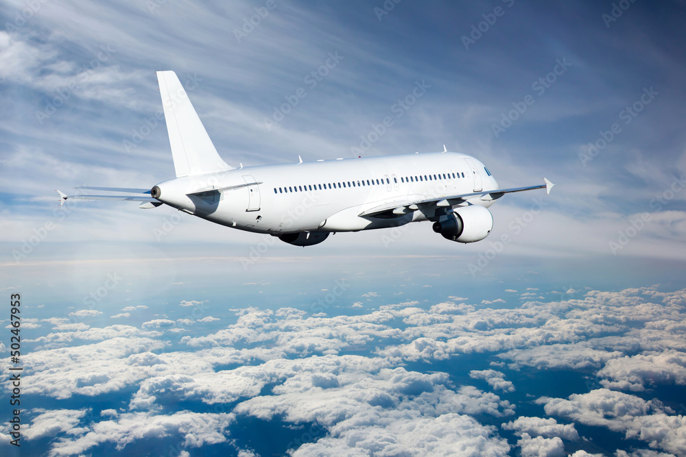 Fototapeta premium White passenger plane in flight above the clouds. Aircraft fly away. Back view of aircraft.