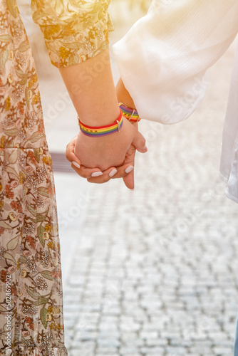 shot of young women LGBT lesbian couple holding hands with LGBT pride.