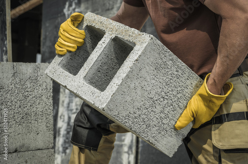 Construction Worker Moving Hollow Dense Concrete Blocks photo