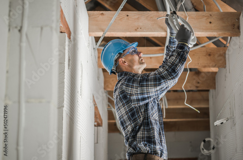 Professional Electrician Installing Ceiling Light Point photo