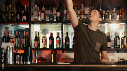 A professional bartender is preparing an alcoholic cocktail with ice cubes to customers at the bar or disco club,Sex on the beach cocktail.