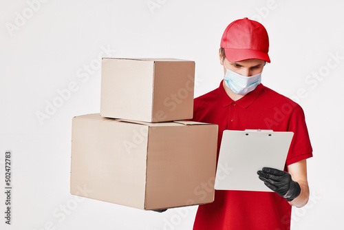 Delivery man employee in red cap face mask, empty cardboard box