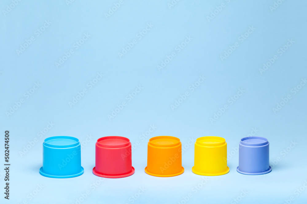 Colorful plastic cylinders on blue background Colorful plastic cylinders on blue background
