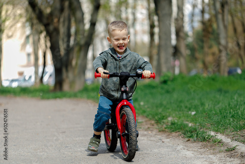 boy riding a bike on the street. Learning to ride a bike concept © Ruslan Ivantsov