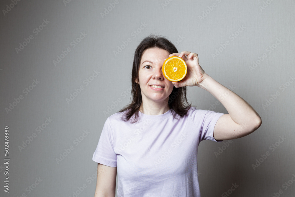 young woman holding an orange in her hand. Healthy food concept young woman holding an orange in her hand. Healthy food concept