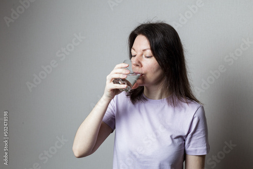 a woman drinks clean water from a glass. healthy food concept