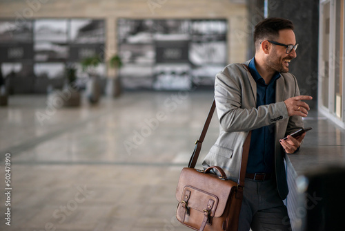 Businessman on bus station, talking to worker on selling tickets