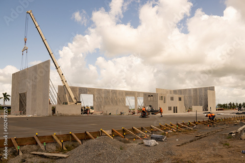 Workmen completing the foundations of a tilt-up warehouse being constructed of prefabricated concrete panels. photo