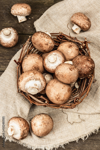 Fresh brown champignons in a wicker basket. Raw ingredients for cooking vegan food