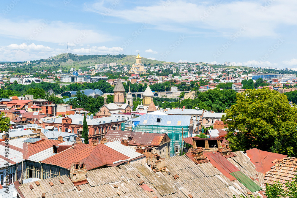 Scenic aerial beautiful view panorama of old historic city Tbilisi center, architecture buildings roofs, Georgia in summer sunny day, nature bright landscape