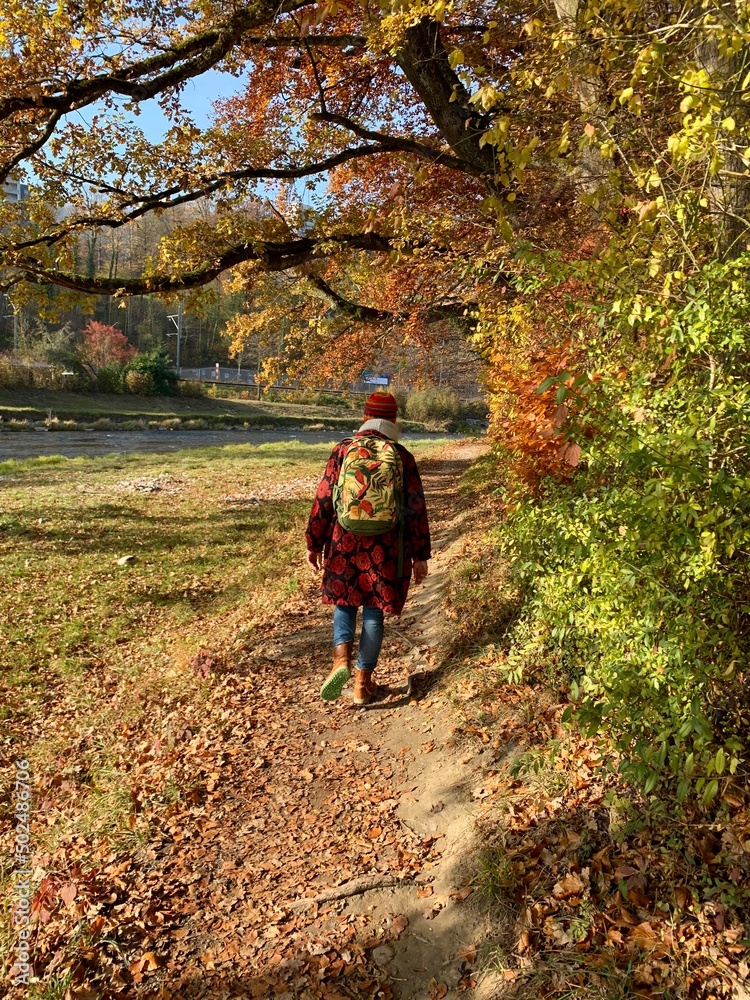 Wanderer im Herbstwald am Fluss Sihl unter bunten Herbstbäume