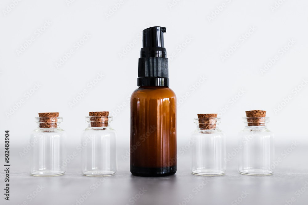 natural beauty and organic ingredients in skincare, amber skincare bottle with small bottles of ingredients next to it natural beauty and organic ingredients in skincare, amber skincare bottle with small bottles of ingredients next to it